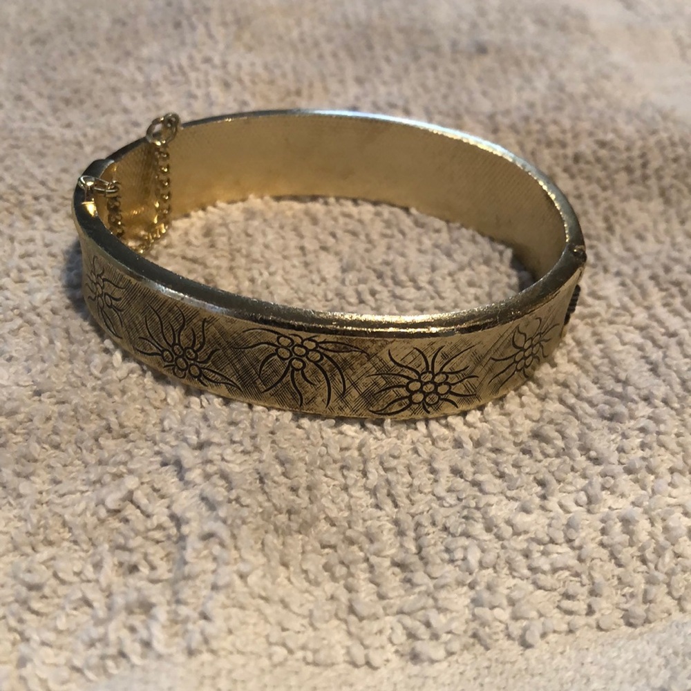 Gold bracelet with engraved design all around, spring hinged